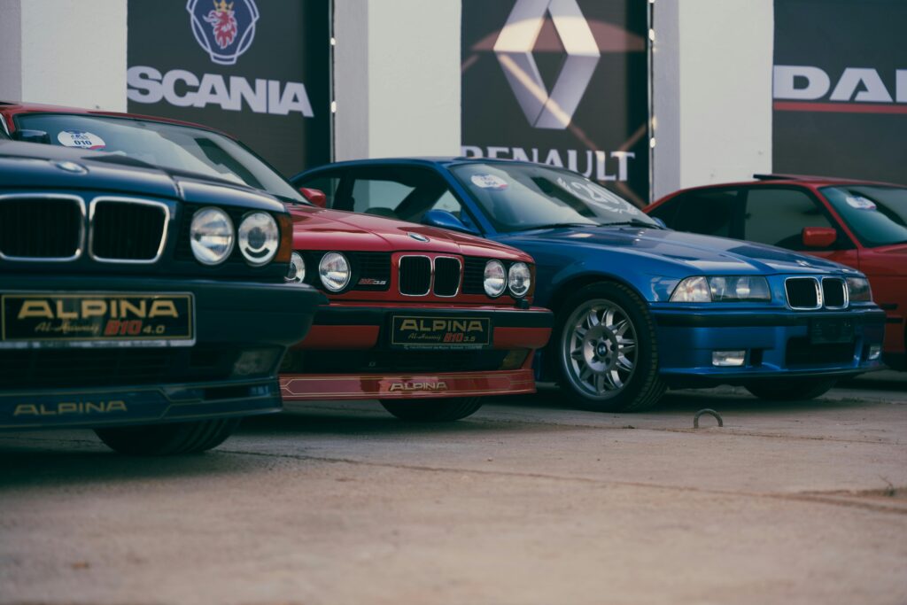 Classic and vintage BMW cars exhibited outdoors with visible brand Alpina and location in Benghazi, Libya.