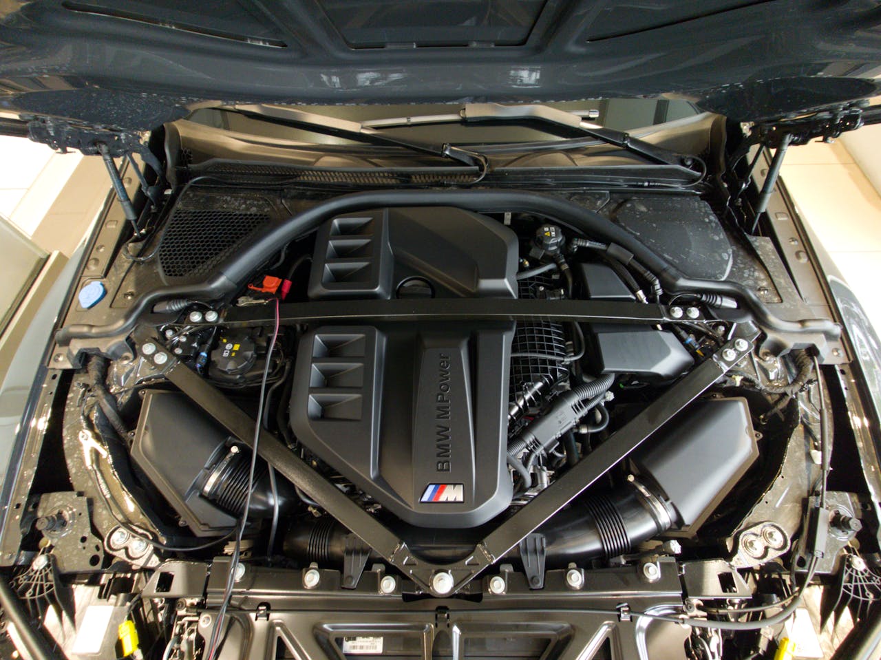 Detailed view of a high-performance car engine under the hood, showcasing its intricate design.